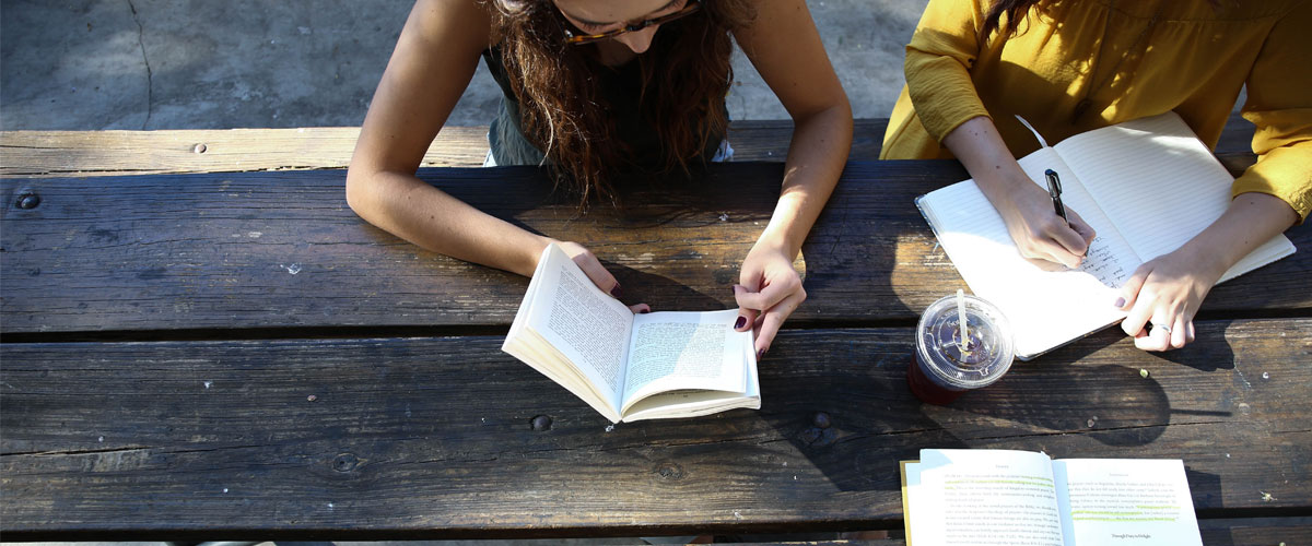 Students reading and working at a wooden table